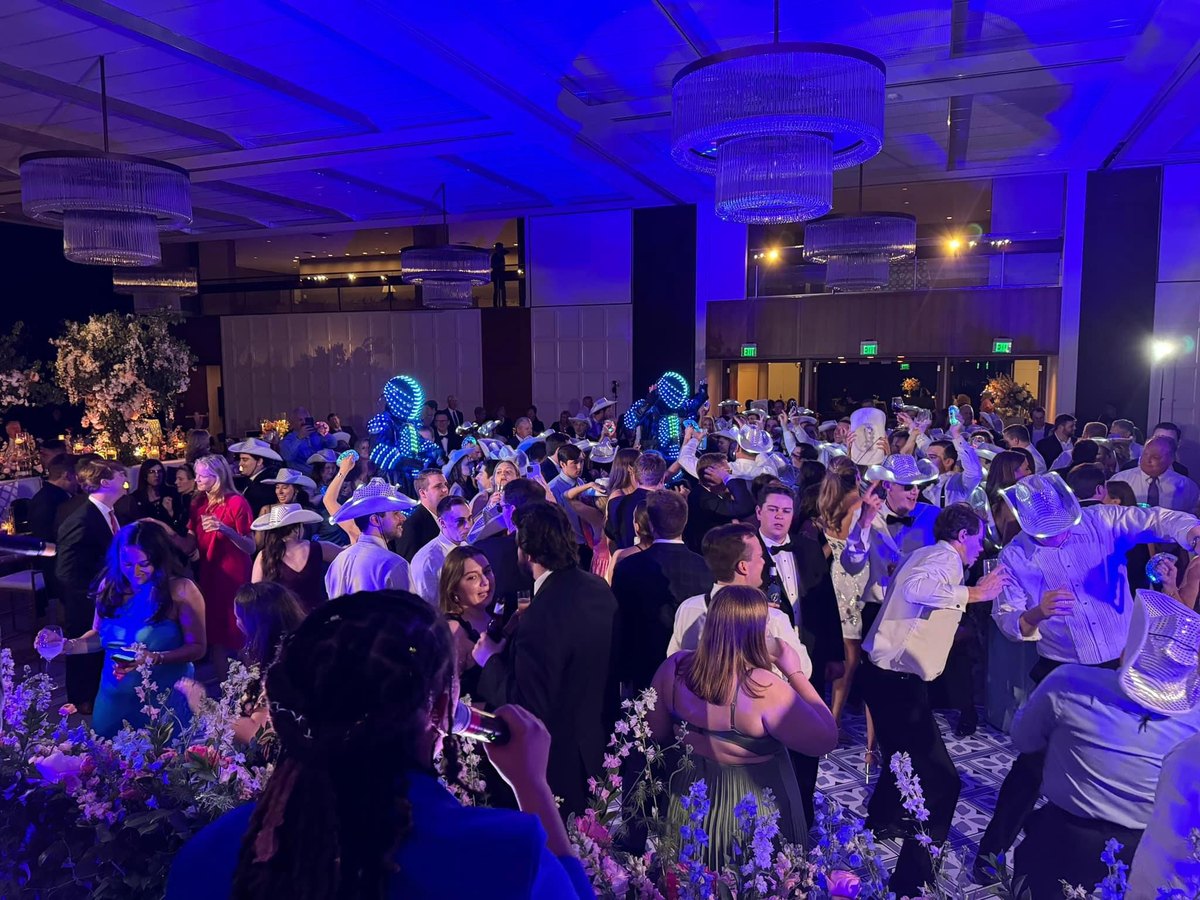 Black-tie guests filling the dance floor at a gala